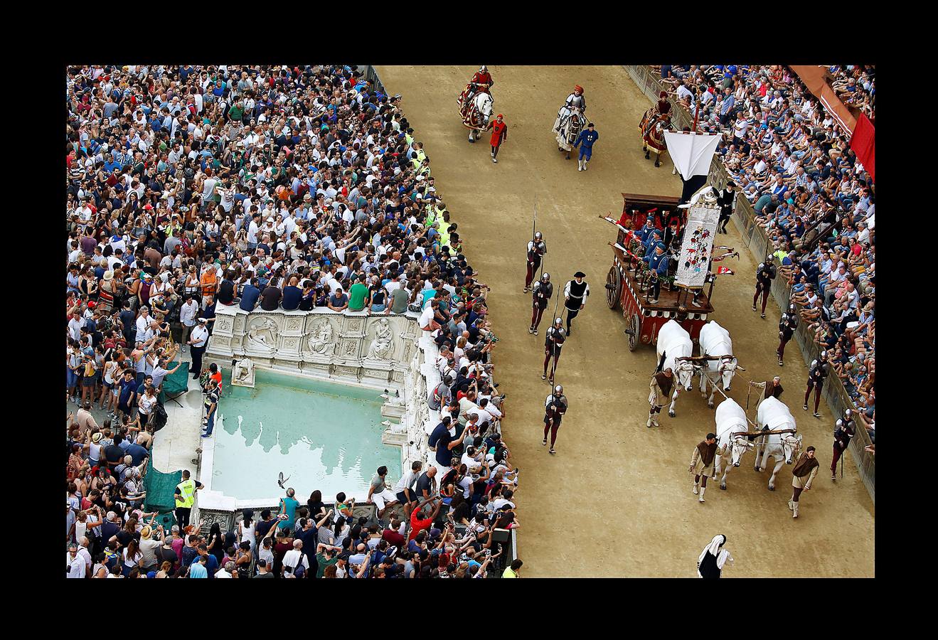 En la Piazza del Campo, en pleno corazón de Siena, en la Toscana, se celebra cada año, en dos ocasiones (las fotografías se tomaron el 2 de julio), la carrera de caballos de origen medieval conocida como «Il Palio.» La ciudad se engalana con estandartes, blasones y guirnaldas para celebrar tres días de alegría durante los cuales, además de participar en las bendiciones de los animales, es posible disfrutar de música y conciertos. En la carrera participan diez caballos, que representan a alguna de las «contradas» o distritos de la ciudad, y han de dar tres vueltas completas a la Piazza del Campo. El primero en terminarlas, con o sin jinete, será el ganador.