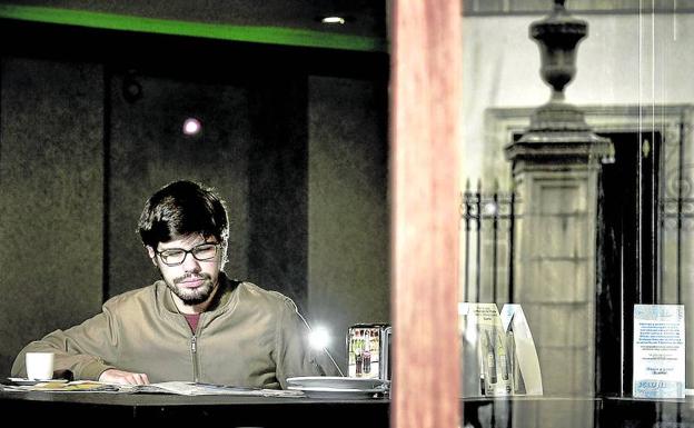 El dirigente de Podemos Lander Martínez lee un periódico en una cafetería situada frente al Parlamento vasco.