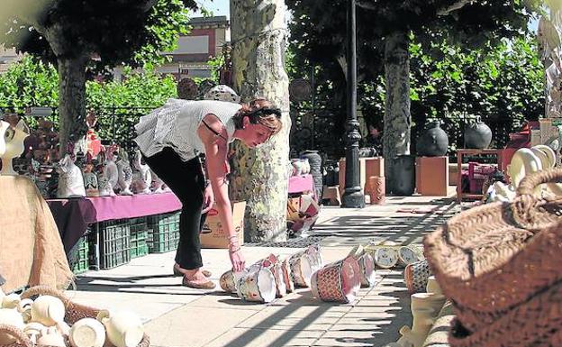 Una mujer examina piezas de cerámica expuestas en una edición pasada de la feria