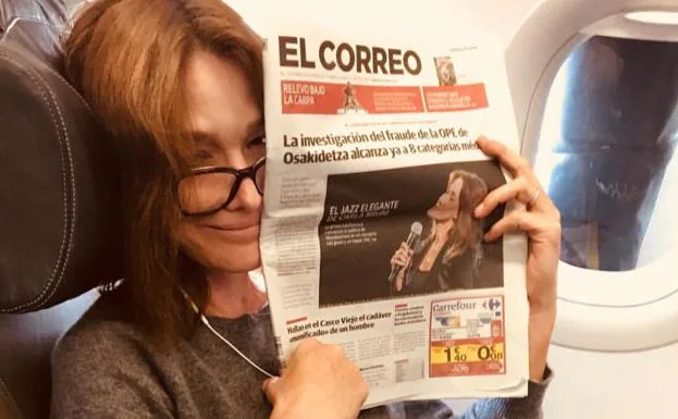 Carla Bruni, en su avión de vuelta a casa con un ejemplar de la edición alavesa de EL CORREO. 