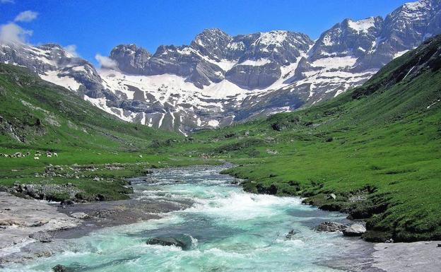 Un torrente de aguas de color turquesa desciende desde el fondo del circo de Estaubè hacia la parte baja del valle.