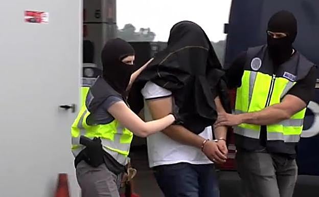 Dos agentes de la Policía Nacional trasladan al detenido en Lopidana a un furgón.