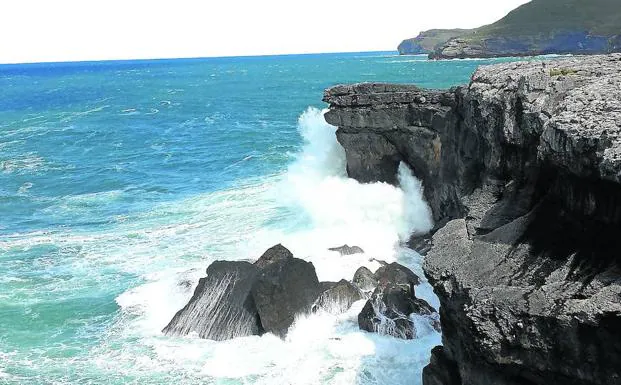 Las olas rompen con violencia en un tramo de la costa de Bareyo, que presenta abundantes oquedades.