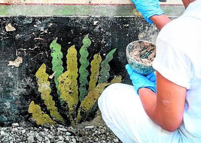 Imagen secundaria 1 - El fresco de los delfines que da nombre a la 'domus'. | Una de las inscripciones que se han descubierto en paredes de edificios, callejuelas y muros. En el centro, una restauradora interviene sobre un fresco.