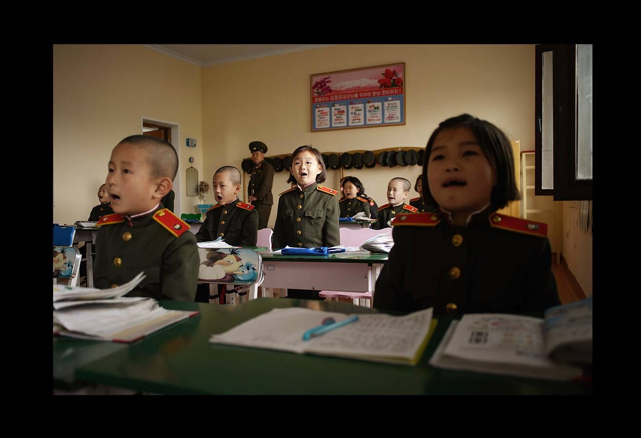 No muchas escuelas tienen aulas equipadas con tanques o simuladores de aviones de caza. La Escuela Revolucionaria Mangyongdae de Corea del Norte no es una institución ordinaria. Fue creada por el fundador del país, Kim Il Sung, para educar a los huérfanos de la guerra contra el gobierno colonial japonés y se ha convertido en un centro que une a la élite gobernante. Unos 1.000 niños con las cabezas rapadas, vestidos de uniforme militar con una línea roja en los pantalones que simboliza su devoción a la causa, ocupan sus clases. Son los escogidos, hijos e hijas de los patriotas que lucharon por el partido, el gobierno y el país; una élite cerrada y hereditaria.