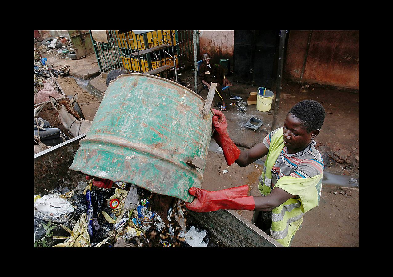 En Bamako, la capital de Mali, los carros tirados por jóvenes como Arouna Diabate (fumando un cigarrillo) y su hermano Salif (con camiseta del Real Madrid), tienen un importante papel en la lucha contra los desechos de la ciudad. Cada mañana, antes del amanecer, los Diabate sujetan el carro a su burro y comienzan las rondas de puerta en puerta para recoger la basura doméstica, que entregan en una estación local de residuos por un salario mensual de 35 dólares. Mali es uno de los países más pobres del mundo y las autoridades tratan de proporcionar servicios adecuados para combatir la proliferación de vertederos informales. La población de Bamako se cuadruplicó desde la década de 1970 hasta alcanzar casi 2 millones de habitantes en 2009.