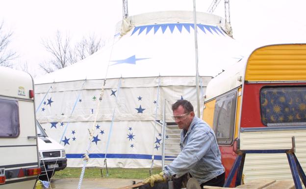 Un hombre trabaja en el montaje de una carpa de circo.