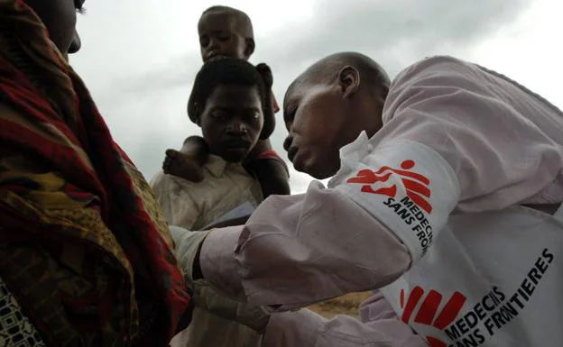 Un sanitario de Médicos sin Fronteras atiende a unos niños congoleños en el campo de refugiados de Dubie.