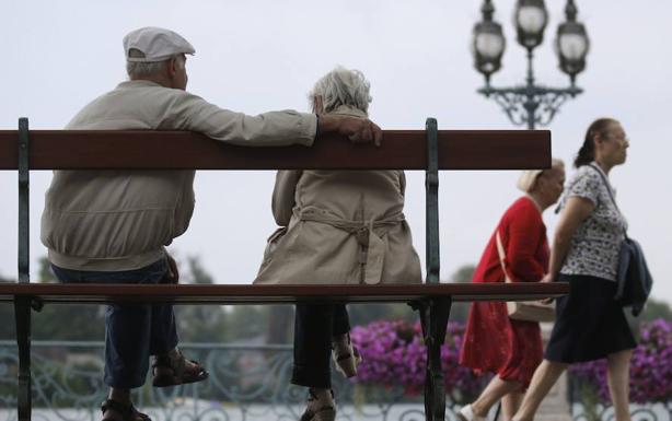 Una pareja de ancianos sentada en un banco. 