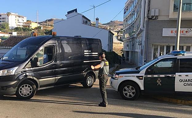 Una furgoneta de los servicios funerarios abandona el lugar en el que ha sido hallado el cadáver de una mujer en Torrox. 