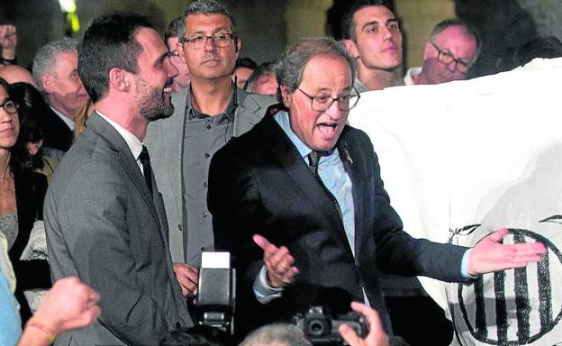 Imagen principal - Símbolos. Torra gesticula junto a los congregados frente al Parlament antes de los incidentes. Abajo, mossos cubiertos de pintura y grupos de los CDR cortando una carretera.