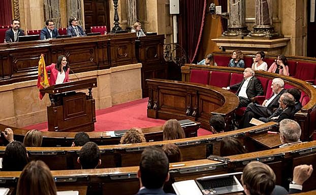 La líder de Ciudadanos, Inés Arrimadas (i), muestra una bandera española durante el turno de réplica. 