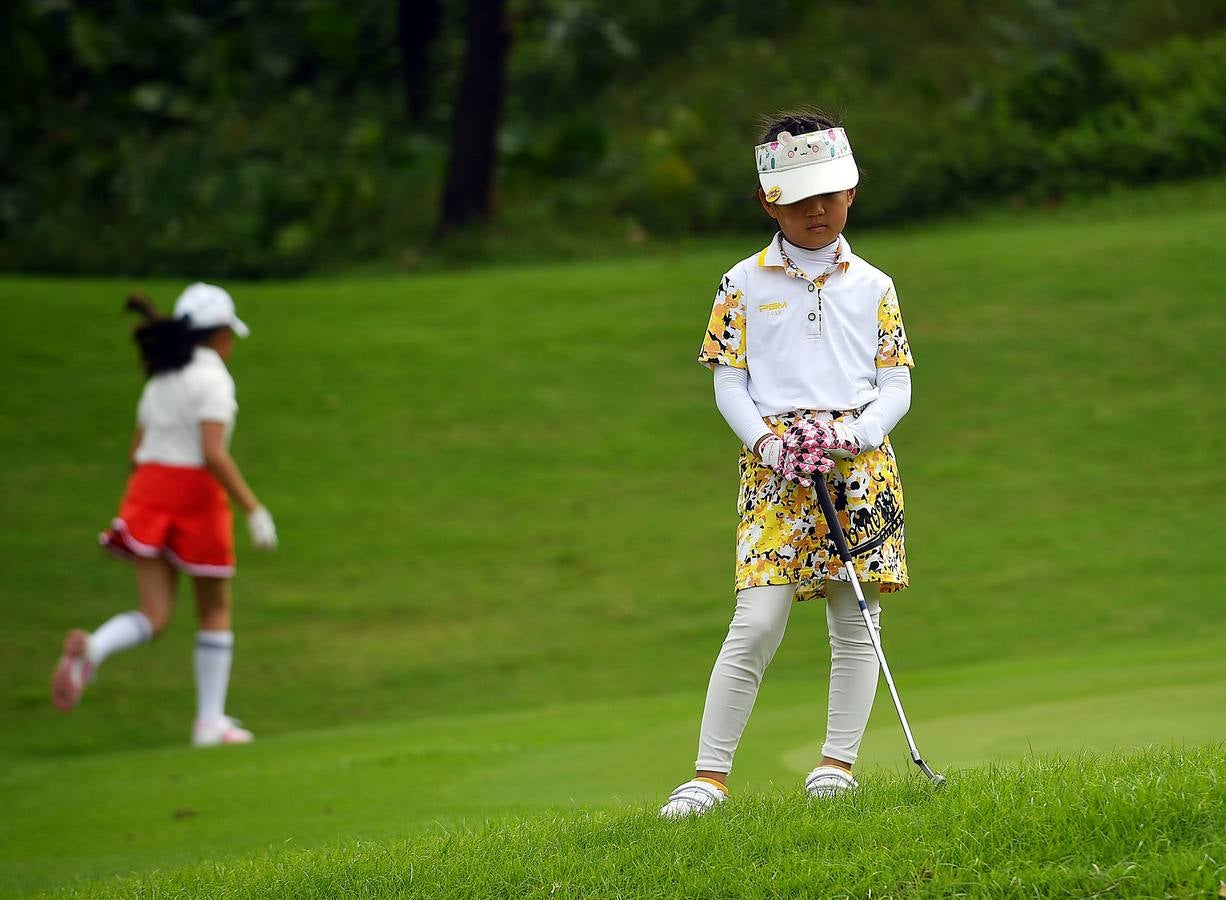 La Asociación China de Golf tenía 400 jugadores juveniles registrados en 2013, el año pasado eran 35.000 y se espera que en un lustro la cifra ronde los 100.000. Lai Runci, de 6 años, y Lai Yiyan, de 9 (protagonistas en la mayoría de las fotos), participan en un torneo para niños en Dragon Lake Golf Club en, Guangzhou. Ambos representan al ejército de jóvenes golfistas de China y el interés creciente del país por un juego que estuvo prohibido bajo el mandato de Mao Zedong porque era «para millonarios...»