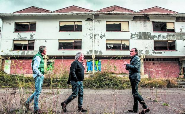 Txus Estívariz, Ramón Breda y Ricardo Urrutia caminan frente al complejo que albergaba la habitación donde coincidieron, en la segunda planta.