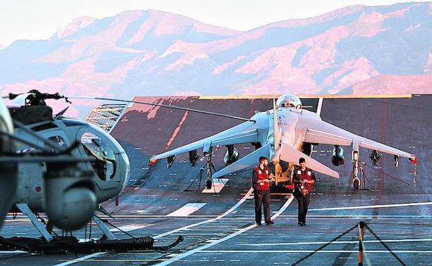 Imagen principal - Arriba, un avión Harrier listo para despegar en el Sky-Jump de la cubierta de vuelo. Después, personal de infantería de Marina delante del dique inundable para el desembarco de unidades anfibias y junto a los vehículos pesados que se guardan en este hangar. Sobre estas líneas, el capitán de navío Francisco José Asensi, comandante del 'Juan Carlos I', en el puente de mando.