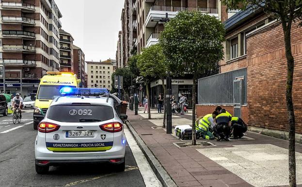 Policías locales y sanitarios atienden a una mujer atacada en la calle Jesús Guridi, de Vitoria.
