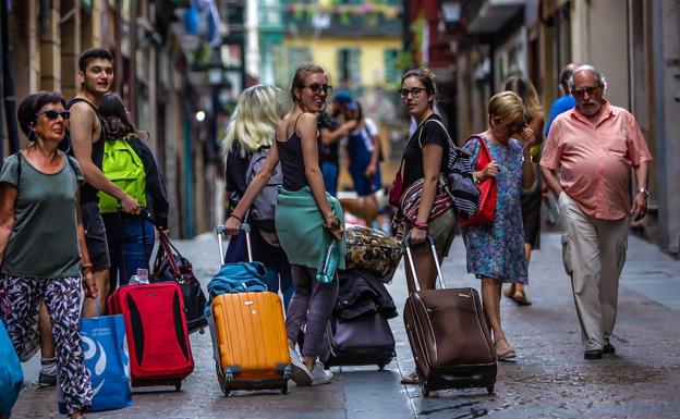 Varios turistas arrastran sus maletas por el Casco Viejo de Bilbao. 