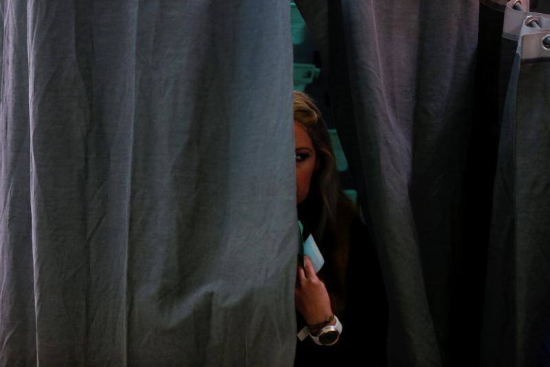 Una mujer sale de la cabina de votación en un colegio electoral de Sevilla.