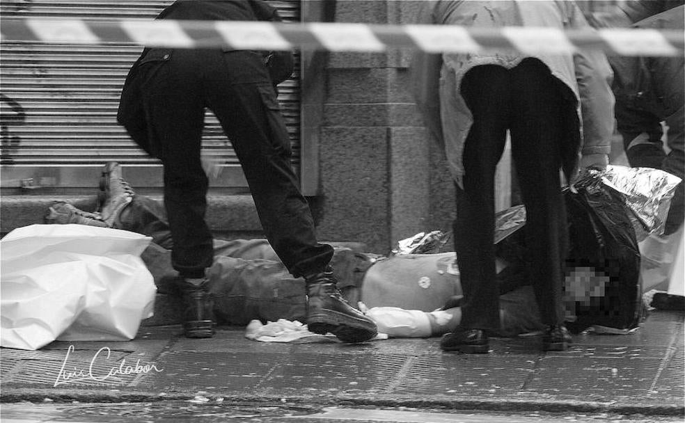 Dos policías observan el cuerpo del joven asesinado.