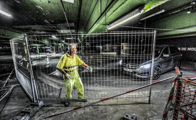 Un operario coloca unas vallas en el interior del parking de Santa Bárbara.