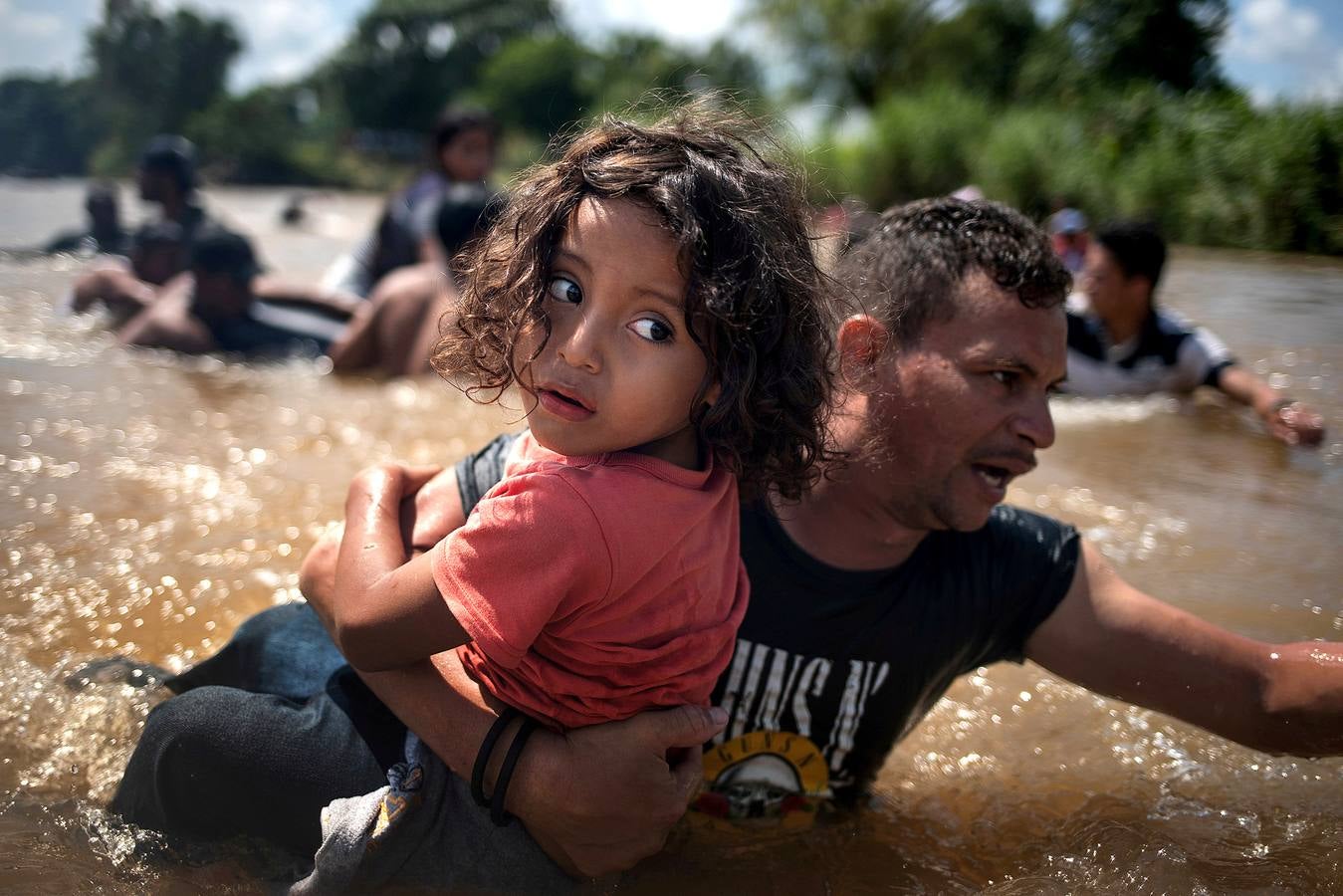 una caravana de inmigrantes de América Central en ruta a los Estados Unidos cruza el río Suchiate hacia México desde Guatemala.