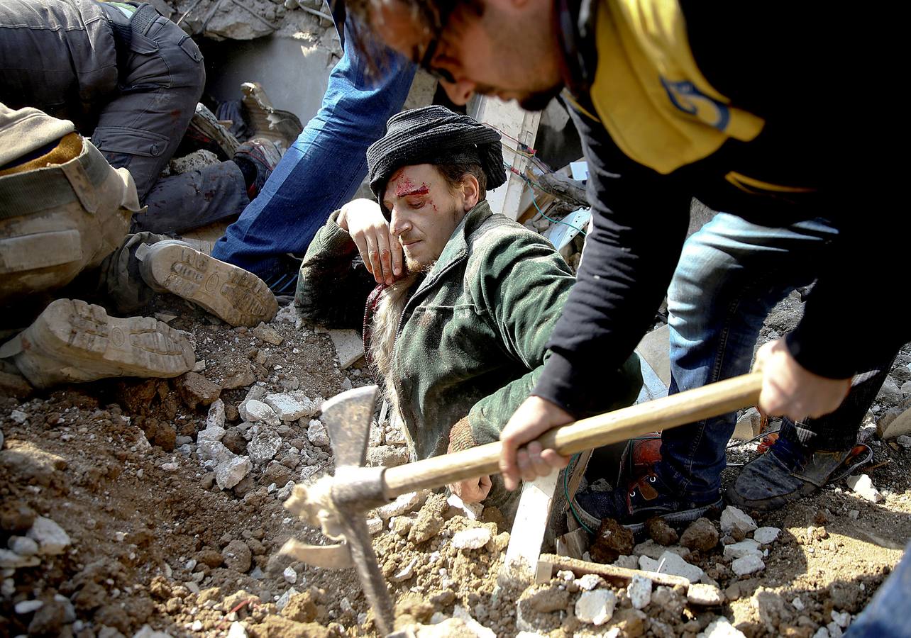 Un hombre queda atrapado bajo los escombros después de un ataque aéreo en el área de Saqba, en el suburbio oriental de Damasco en Ghouta, Siria.