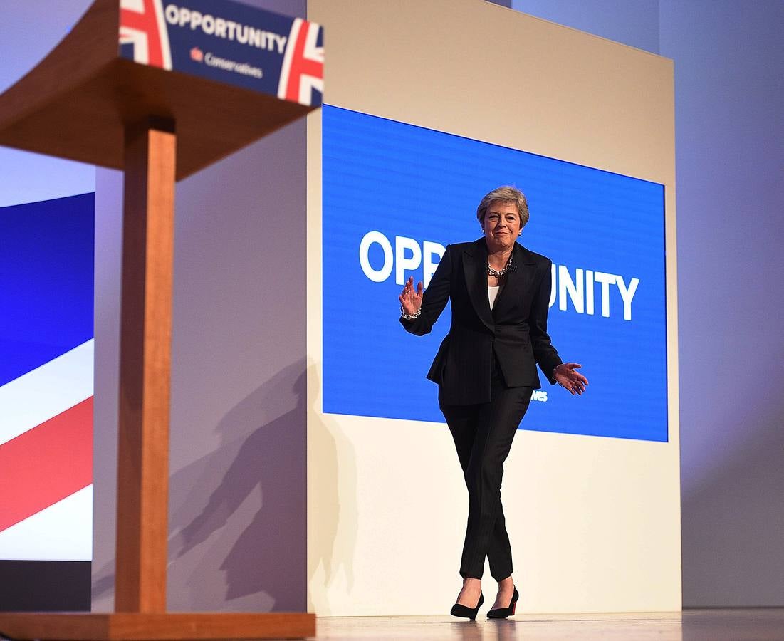 La primera ministra británica, Theresa May, baila unos pasos mientras sube al escenario para dar su discurso de apertura en el cuarto y último día de la Conferencia del Partido Conservador 2018 en el Centro de Convenciones Internacional de Birmingham, en el centro de Inglaterra.