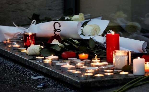 Ciudadanos encienden velas y escriben mensajes en el lugar donde falleció una de las víctimas del atentado. 