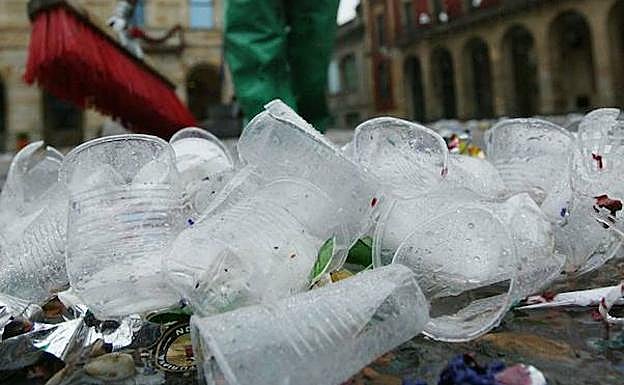 Un barrendero retira decenas de vasos de plástico de la calle. E. C.