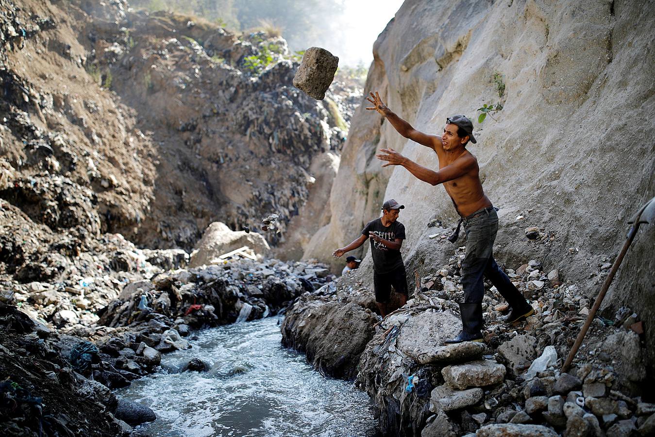 'La Mina', en la ciudad de Guatemala, se encuentra al fondo de un barranco atravesado por un río. Centenares de personas se afanan cada día entre sus aguas contaminadas, bajo la amenaza de deslizamientos y enfermedades, para tratar de encontrar objetos o chatarra con la que ganarse la vida. Algunos utilizan imanes para atraparlos, otros lo hacen a mano, introduciendo su cuerpo directamente en el agua, convertida en basurero. Si hay suerte pueden conseguir unos 20 dólares, el doble del salario mínimo. En ocasiones hasta es posible hallar un anillo o un pendiente de oro.