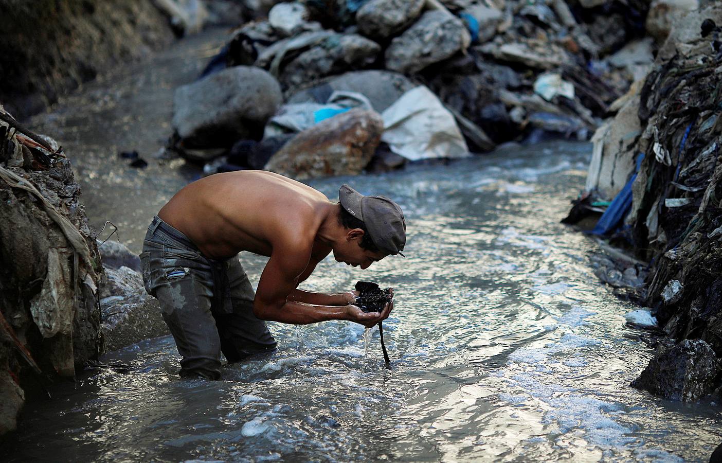 'La Mina', en la ciudad de Guatemala, se encuentra al fondo de un barranco atravesado por un río. Centenares de personas se afanan cada día entre sus aguas contaminadas, bajo la amenaza de deslizamientos y enfermedades, para tratar de encontrar objetos o chatarra con la que ganarse la vida. Algunos utilizan imanes para atraparlos, otros lo hacen a mano, introduciendo su cuerpo directamente en el agua, convertida en basurero. Si hay suerte pueden conseguir unos 20 dólares, el doble del salario mínimo. En ocasiones hasta es posible hallar un anillo o un pendiente de oro.