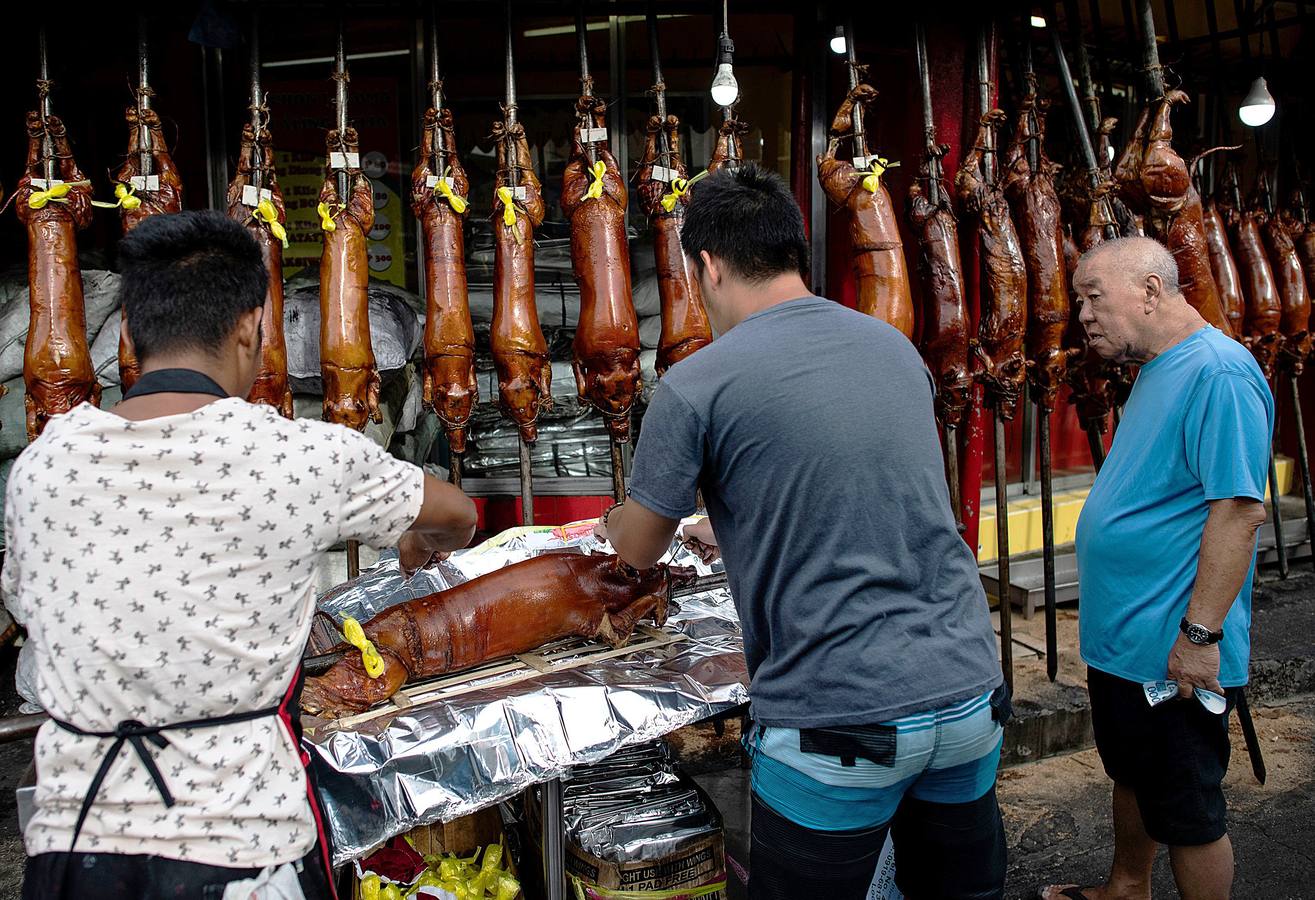 El territorio filipino está compuesto por más de 7.000 islas en las que se distribuyen los 100 millones de habitantes del país. Su complicada interconexión insular ha facilitado la aparición en el tiempo de una enorme variedad de lenguas y comidas locales. Una de ellas es el lechón relleno con papaya y hojas de tamarindo, que se pone a la brasa y se sirve con arroz acompañado con salsa de hígado. Los lechoneros (los vemos en las fotos) se dedican a girar el asado durante horas y lo bañan de tanto en tanto con agua de coco.
