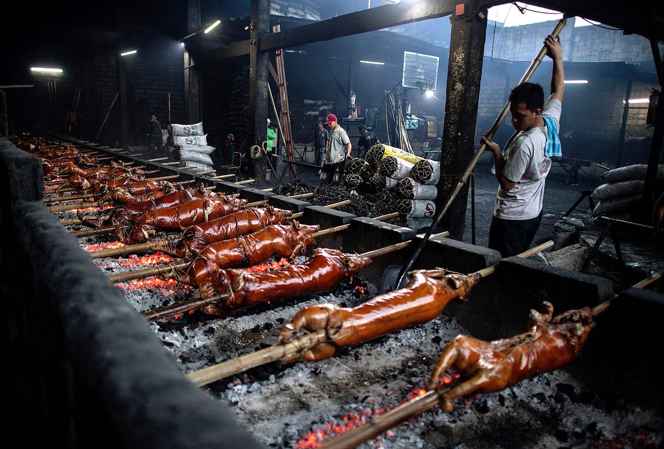 El territorio filipino está compuesto por más de 7.000 islas en las que se distribuyen los 100 millones de habitantes del país. Su complicada interconexión insular ha facilitado la aparición en el tiempo de una enorme variedad de lenguas y comidas locales. Una de ellas es el lechón relleno con papaya y hojas de tamarindo, que se pone a la brasa y se sirve con arroz acompañado con salsa de hígado. Los lechoneros (los vemos en las fotos) se dedican a girar el asado durante horas y lo bañan de tanto en tanto con agua de coco.
