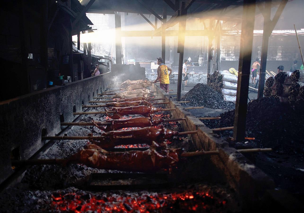 El territorio filipino está compuesto por más de 7.000 islas en las que se distribuyen los 100 millones de habitantes del país. Su complicada interconexión insular ha facilitado la aparición en el tiempo de una enorme variedad de lenguas y comidas locales. Una de ellas es el lechón relleno con papaya y hojas de tamarindo, que se pone a la brasa y se sirve con arroz acompañado con salsa de hígado. Los lechoneros (los vemos en las fotos) se dedican a girar el asado durante horas y lo bañan de tanto en tanto con agua de coco.