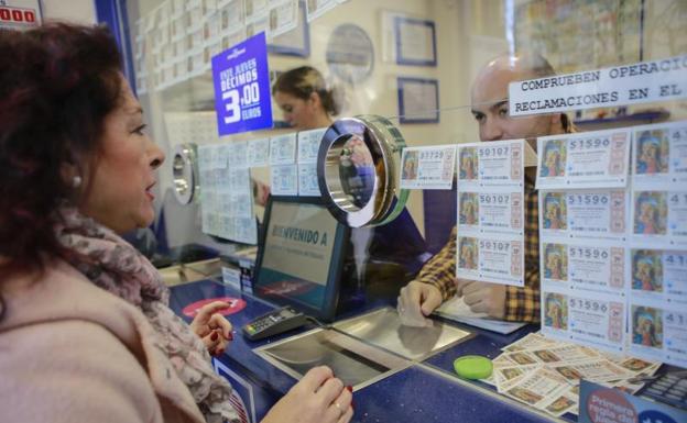 Una mujer compra un décimo en una administracion vitoriana.