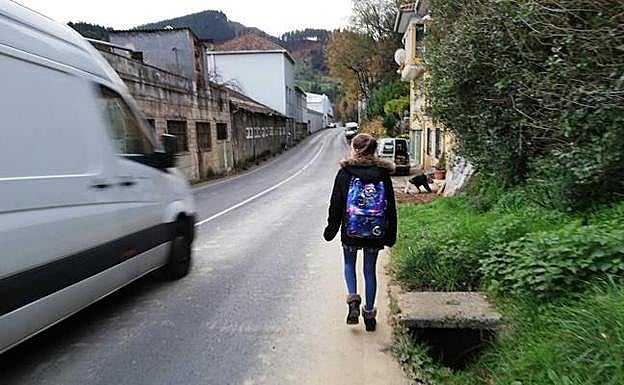 La falta de una parada más próxima obliga a recorrer un estrecho arcén para coger el autobús. 