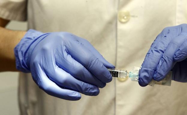 Una sanitaria prepara una vacuna para la gripe.