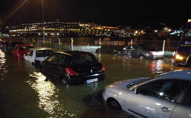 Coches aparcados en la ribera de Elorrieta, rodeados de agua. 