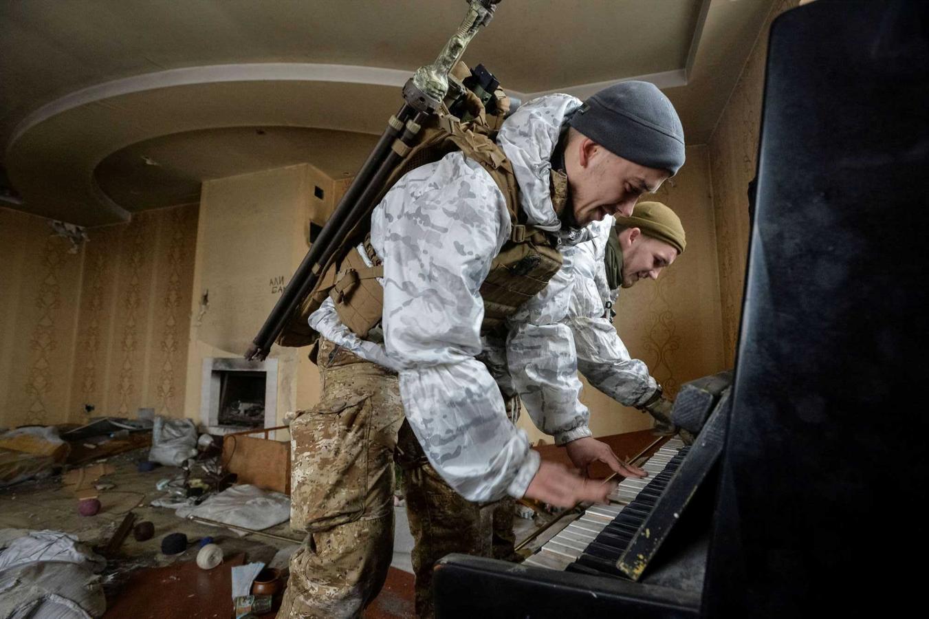 Soldados del ejército ucraniano tocan el piano en una casa destruída por los combates en el frente de Donetsk