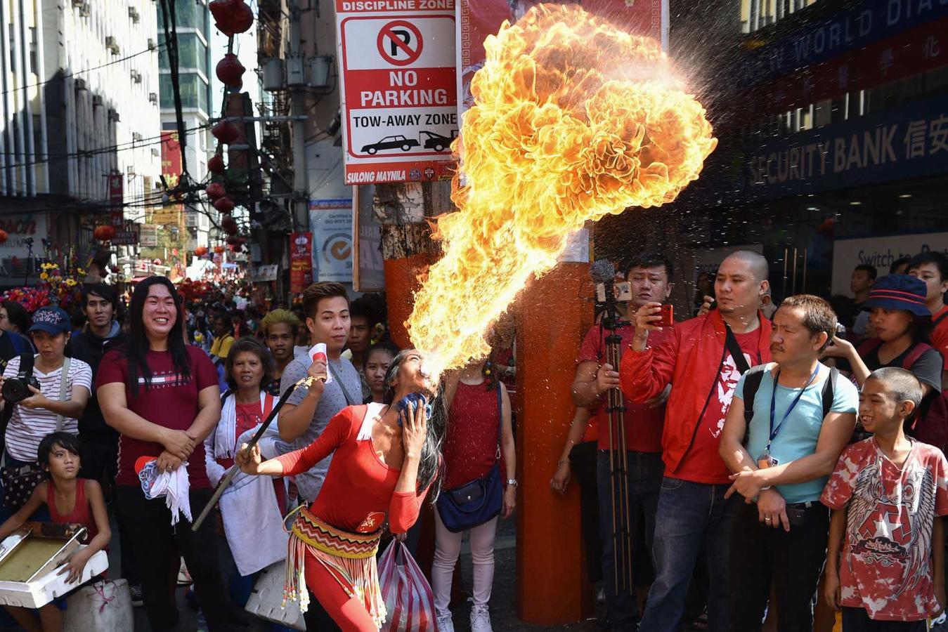 Una faquir escupe fuego durante las celebraciones por la llegada del Año del Cerdo, en el barrio chino de Manila (Filipinas)