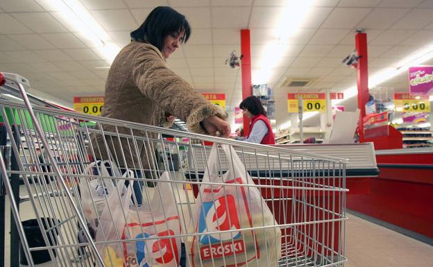 Consumidora llevando la compra en una bolsa de plastico, en Vitoria.