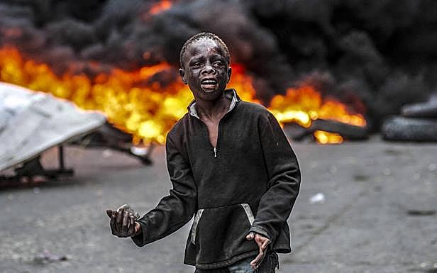 Un niño se dispone a lanzar una piedra en las protesta en Puerto Príncipe.