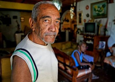 Imagen secundaria 1 - Arriba, una vista del cerro José Félix Ribas, una de las favelas más grandes de América Latina. A la izquierda, Enrique, cuñado. A la derecha, un vecino. 