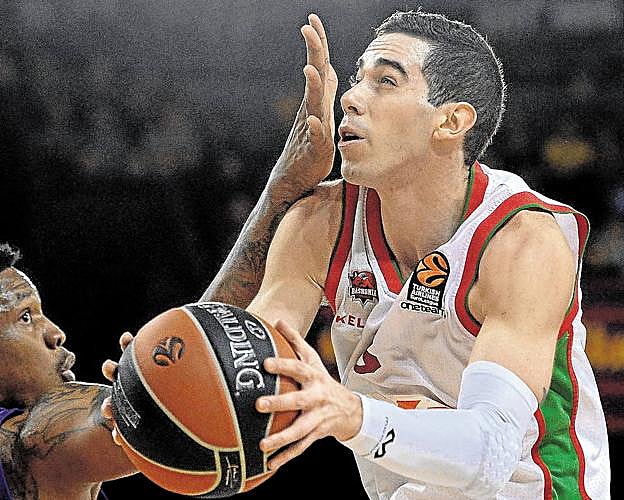 Luca Vildoza culmina una entrada a canasta con la mano de Kevin Seraphin delante del rostro.