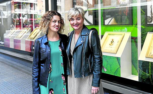 Las diseñadoras Laura Piedra y Mari Carmen Navarro, frente a la muestra en los escaparates de El Corte Inglés de Bilbao.