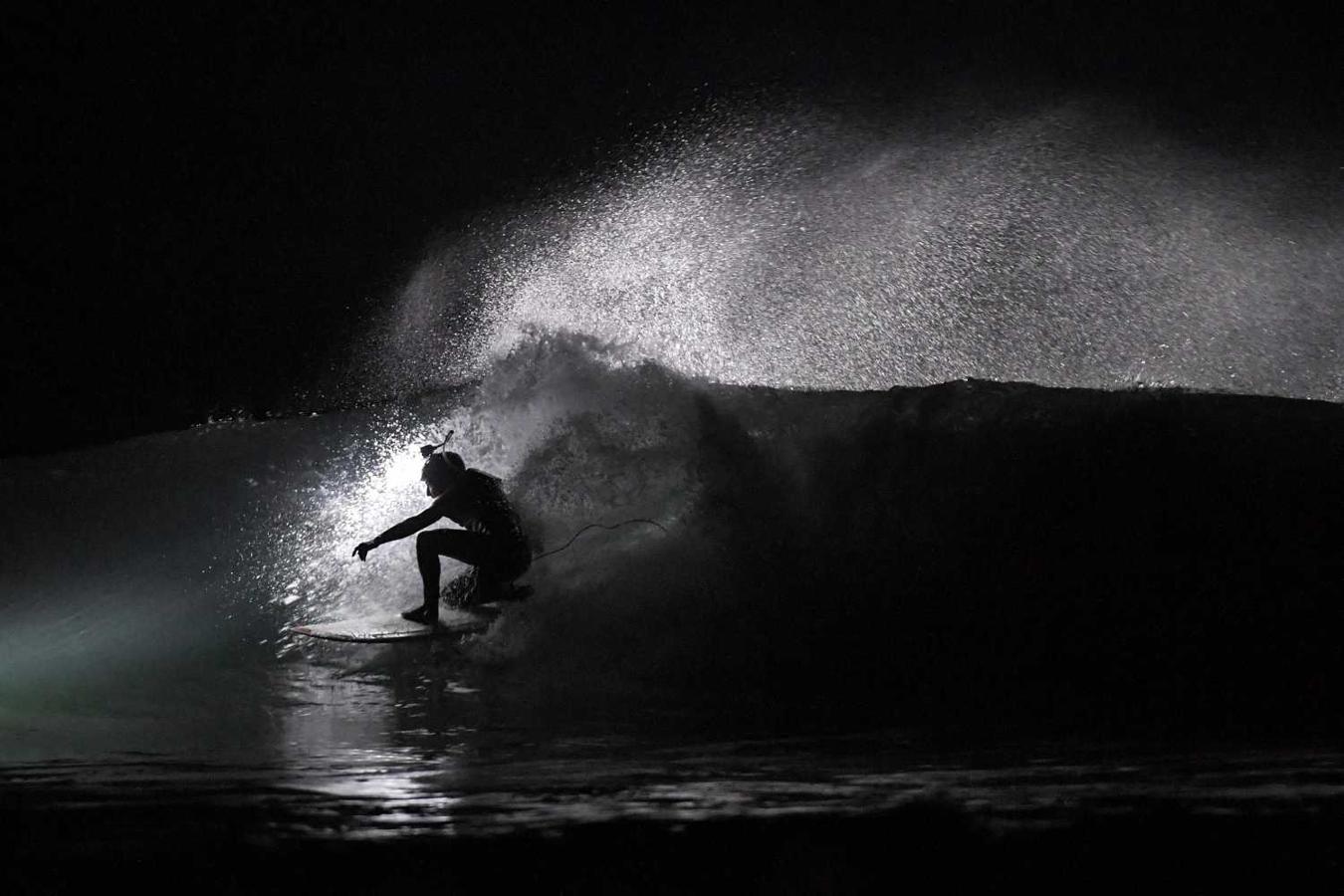 Los surfistas Yann Le Her, Alan, Yohann, Robin y Damien desafían el frío y la oscuridad en una sesión de surf nocturno en la playa del Cabo Fréhel, Bretaña