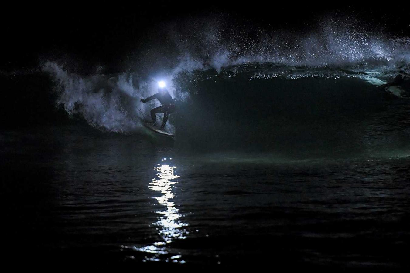 Los surfistas Yann Le Her, Alan, Yohann, Robin y Damien desafían el frío y la oscuridad en una sesión de surf nocturno en la playa del Cabo Fréhel, Bretaña
