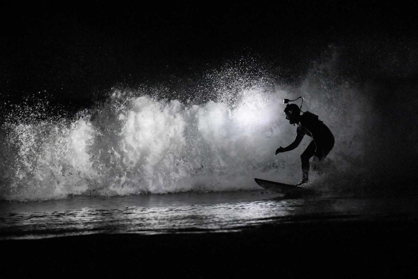 Los surfistas Yann Le Her, Alan, Yohann, Robin y Damien desafían el frío y la oscuridad en una sesión de surf nocturno en la playa del Cabo Fréhel, Bretaña