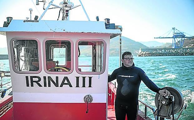 El mariscador, con el traje de neopreno, a bordo del 'Irina III', su pequeño pesquero. 