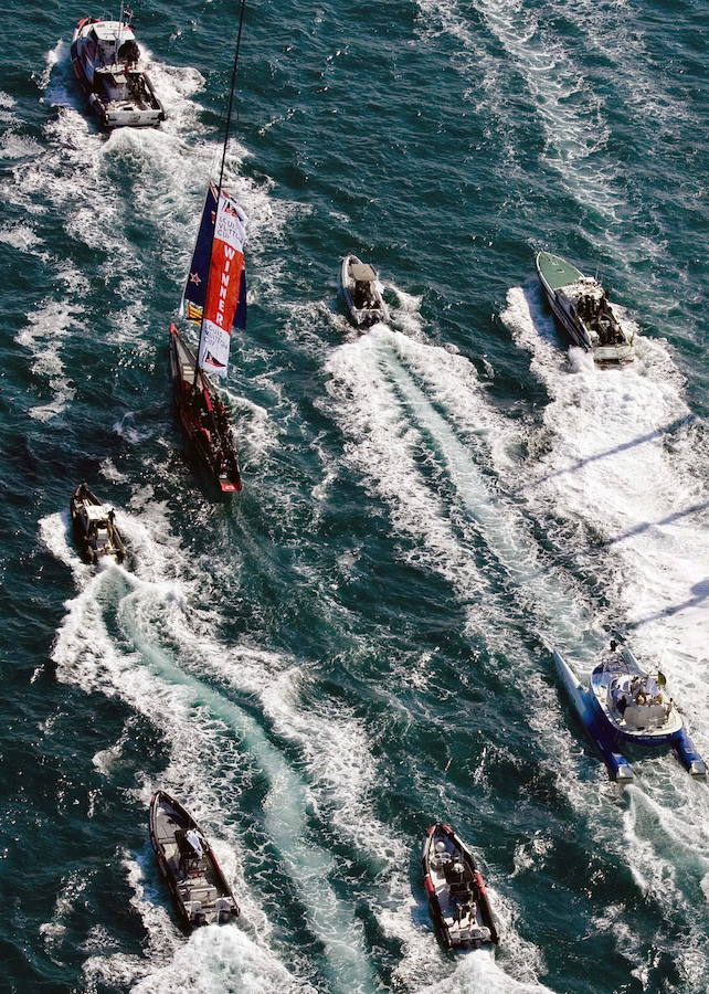 La tripulación del Emirates Team New Zealand navega con la bandera de los ganadores tras la final de la Louis Vuitton Cup en la costa de Valencia, España.